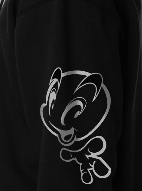 A close-up view of a black sweatshirt featuring a minimalistic white character design on the side sleeve.