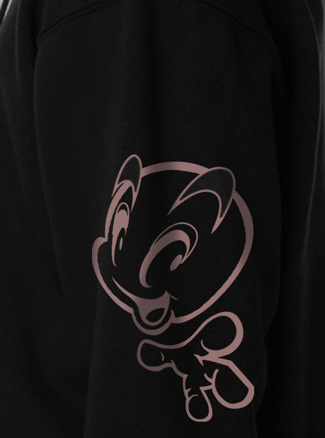 A close-up view of a black sweatshirt featuring a minimalistic pink character design on the side sleeve.