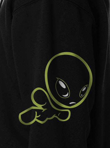 A close-up view of a black sweatshirt featuring a minimalistic green character design on the side sleeve.